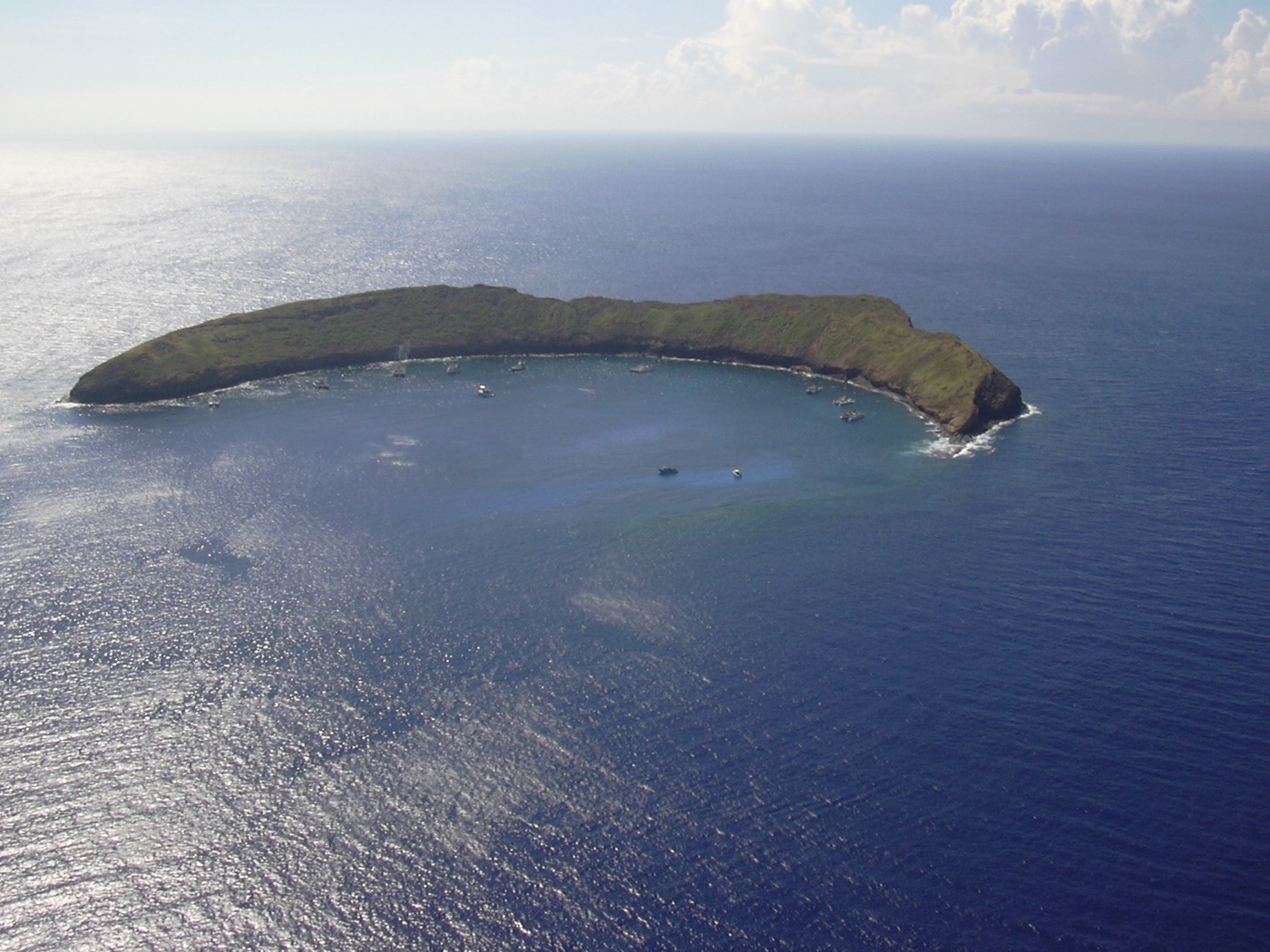 Aerial view of the crescent-shaped Molokini crater rising out of the deep blue ocean off Maui
