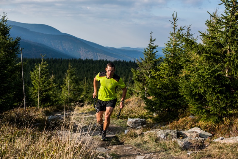 A trail runner in outdoor apparel on a mountain path