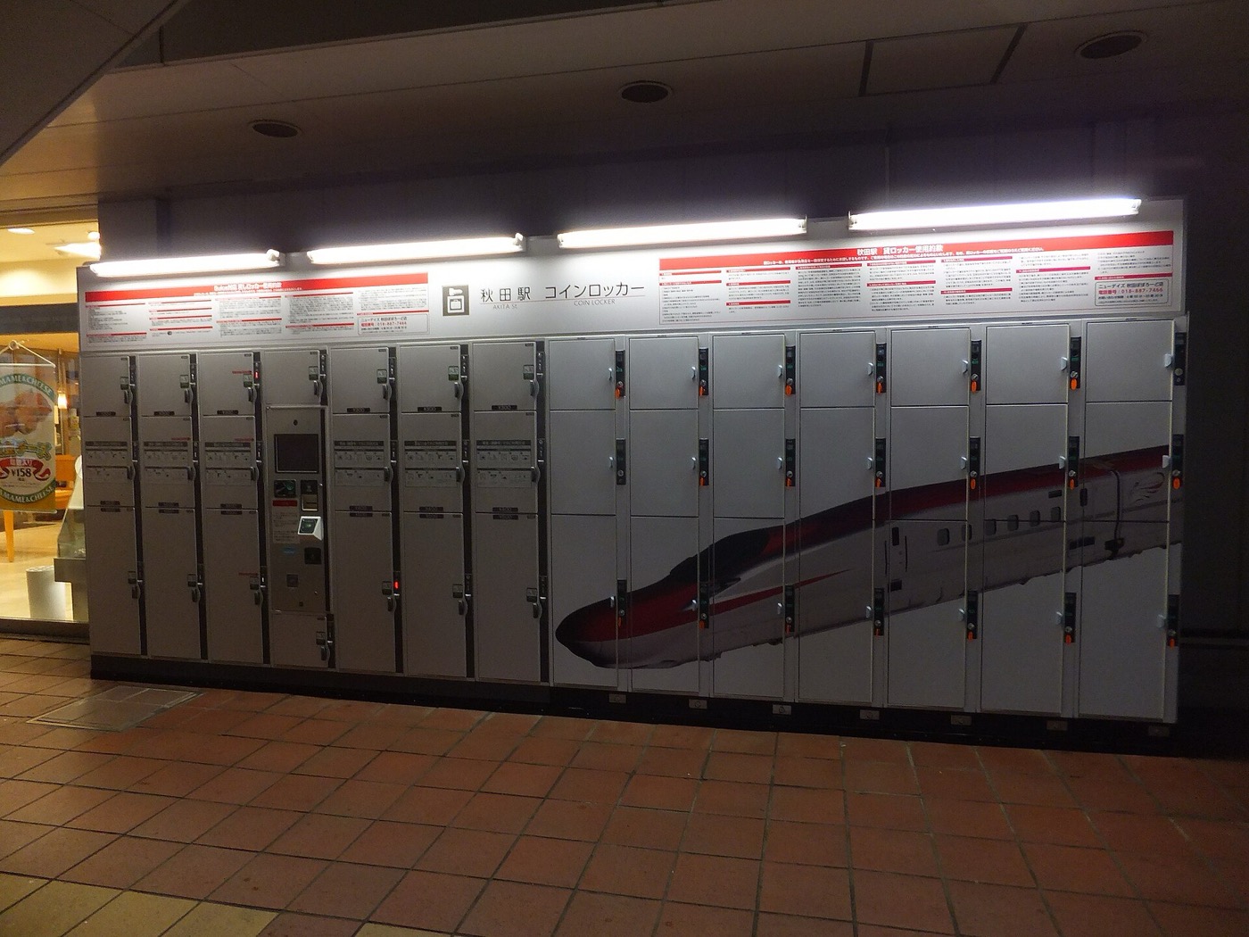 A wall of coin-operated luggage lockers inside a Japanese train station