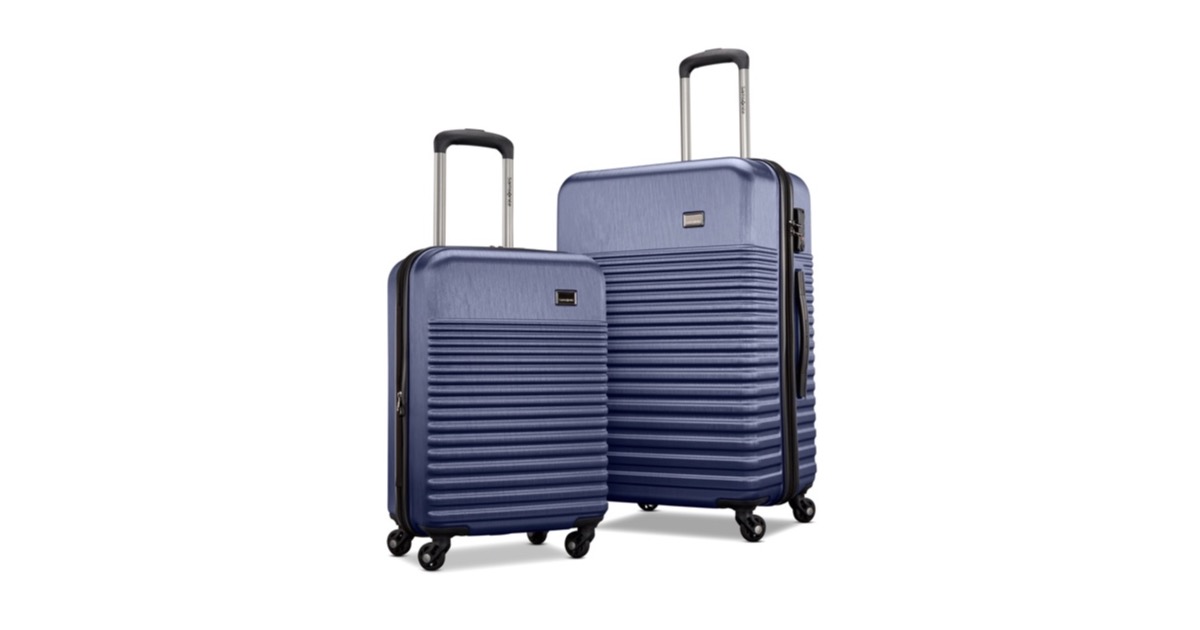 A Samsonite two piece hardside luggage set in navy blue, a carry-on spinner beside a larger checked spinner