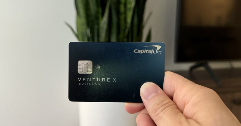 A hand holding a Capital One Venture X card